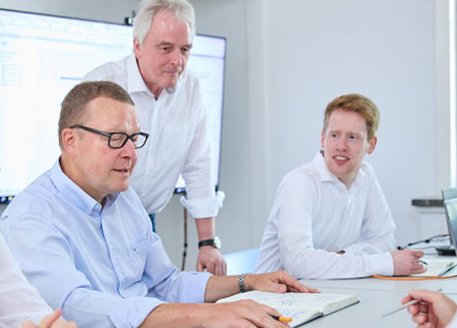 Gruppe von Maschinenbauingenieuren sitzt am Besprechungstisch